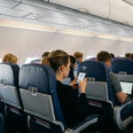 Darmowy internet Starlink i wi-fi w samolocie Wizz Air. Pasażer trzyma smartfon z aktywnym połączeniem internetowym podczas lotu tanią linią lotniczą.