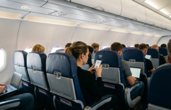 Darmowy internet Starlink i wi-fi w samolocie Wizz Air. Pasażer trzyma smartfon z aktywnym połączeniem internetowym podczas lotu tanią linią lotniczą.