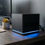 Czarna matowa konsola Steam Machine od Valve z niebieską listwą LED na biurku. Futurystyczny design i nowoczesna technologia gamingowa nowej generacji 2026.