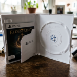 Otwarte pudełko gry na PS5 bez płyty w środku. Puste opakowanie PlayStation symbolizuje dystrybucję cyfrową gier i brak fizycznych wydań na konsole Sony.