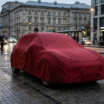 Sportowy samochód GWM Ora 5 GT pod czerwoną płachtą w mieście. Model zapowiadający polski debiut marki GWM w kategorii motoryzacja i mobilność.