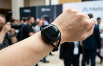 Okrągły Meta Charm wielkości etui AirPods z czarnym wyświetlaczem i sznurkiem. Asystent Muse AI od Meta Marka Zuckerberga zamiast tradycyjnego smartfona.