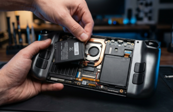 Dłonie wymieniają modularną baterię w Nintendo Switch 2. Metalowa obudowa konsoli do gier w niebieskim świetle studio. Newsy gaming, Polska i świat.